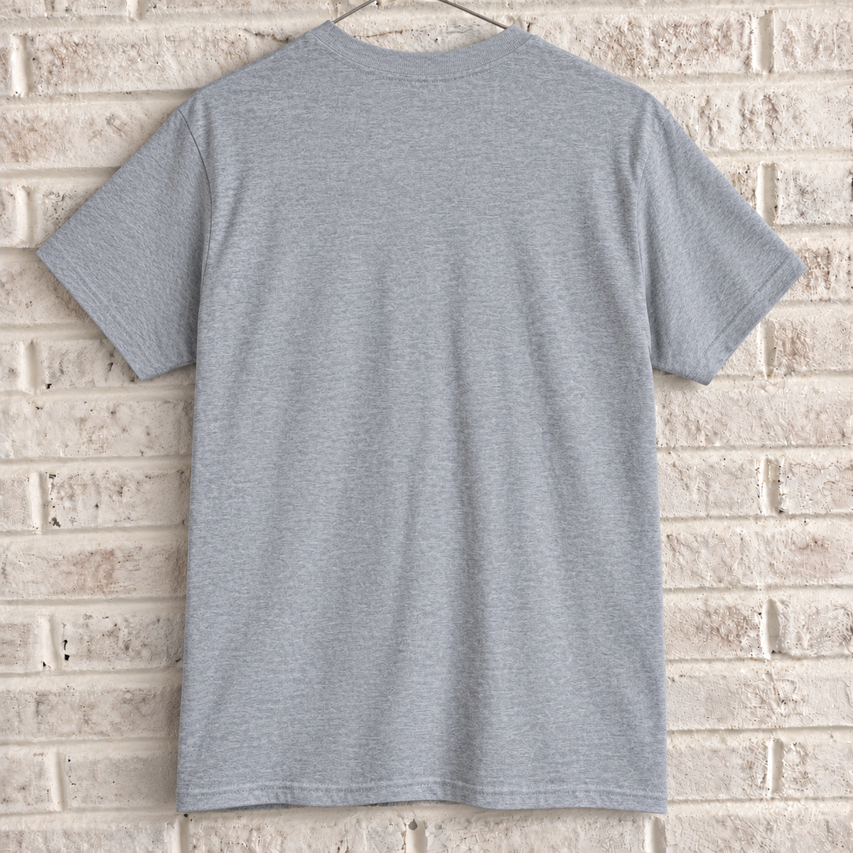 Grey London phone box and guard graphic tee on a white brick wall with a wire hanger — blank back view