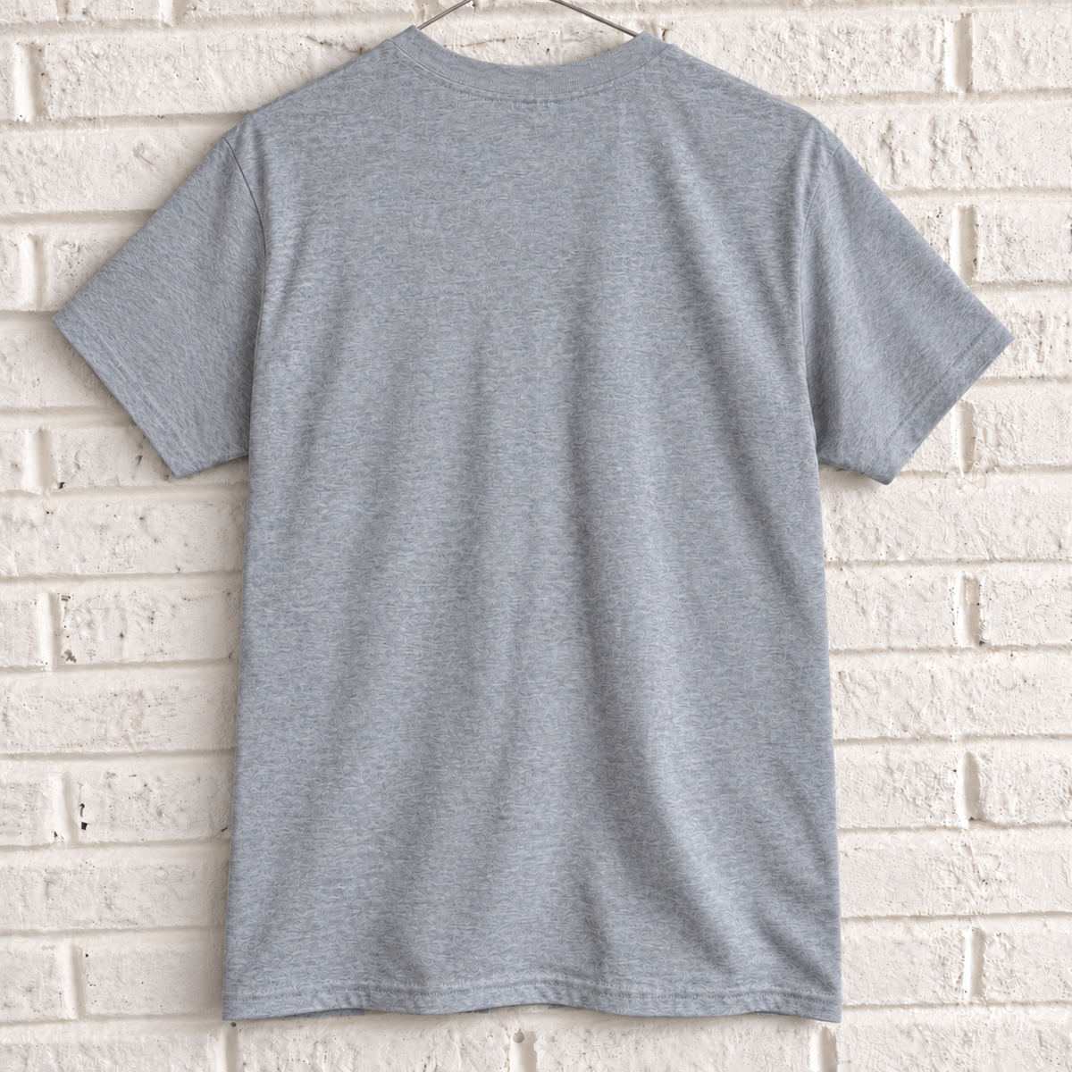 Grey London phone box and guard graphic tee on a white brick wall with a wire hanger — blank back view