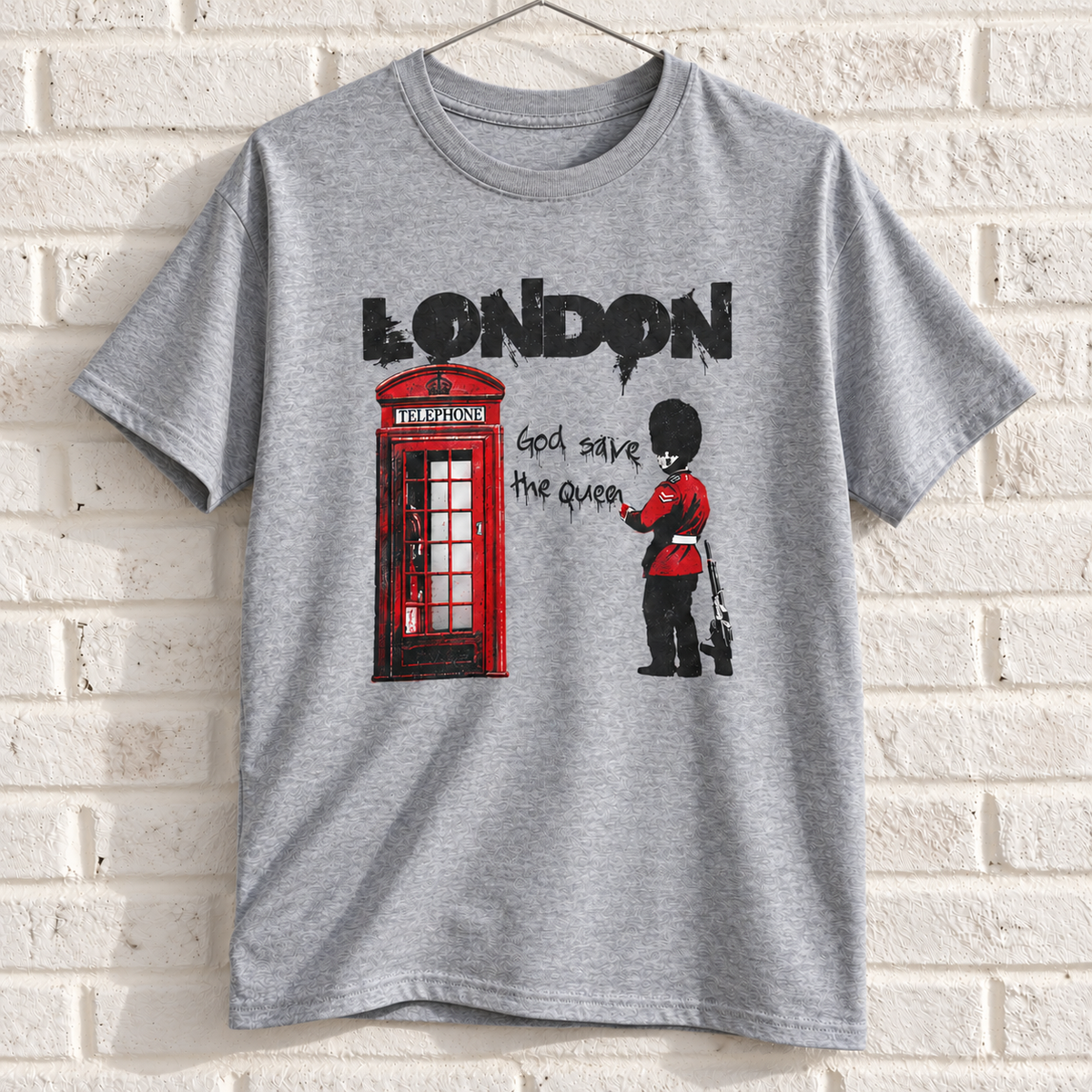 Grey London phone box and guard graphic tee on a white brick wall with a wire hanger — front view