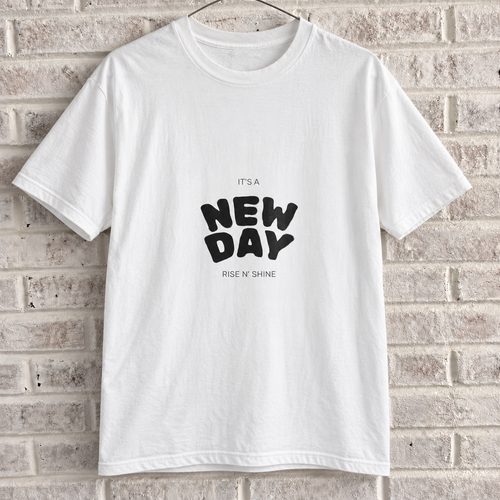White Comfort Colors graphic tee on a white brick wall with a wire hanger — front view