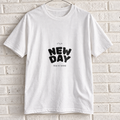 White Comfort Colors graphic tee on a white brick wall with a wire hanger — front view